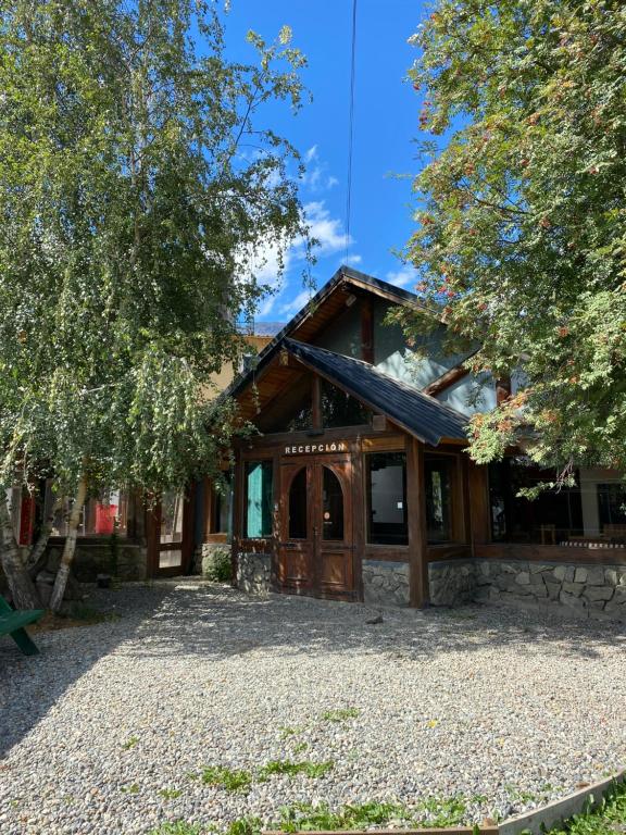 a house with a stone driveway in front of it at Hostel Otto Tipp in El Bolsón