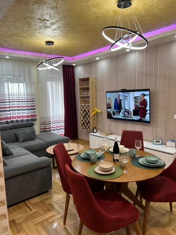 ein Wohnzimmer mit einem Tisch und einem Sofa in der Unterkunft Apartman Branković Pirot-Zapadni Kej 58 in Pirot