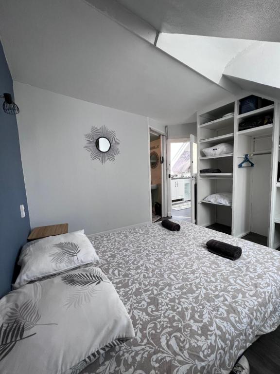 ein Schlafzimmer mit einem Bett mit zwei schwarzen Schuhen darauf in der Unterkunft L'ancre Bleue in Dieppe