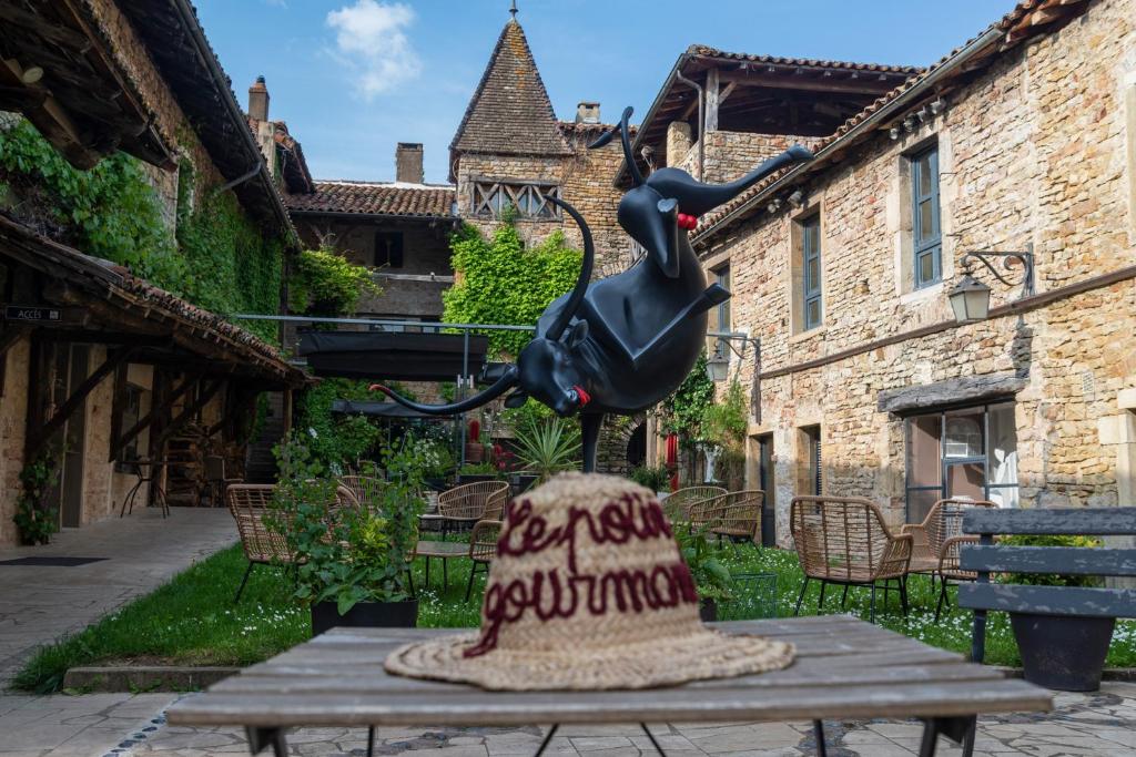 une statue d'un oiseau assis au-dessus d'une table dans l'établissement Art'Hotel & SPA Le Potin Gourmand, à Cluny