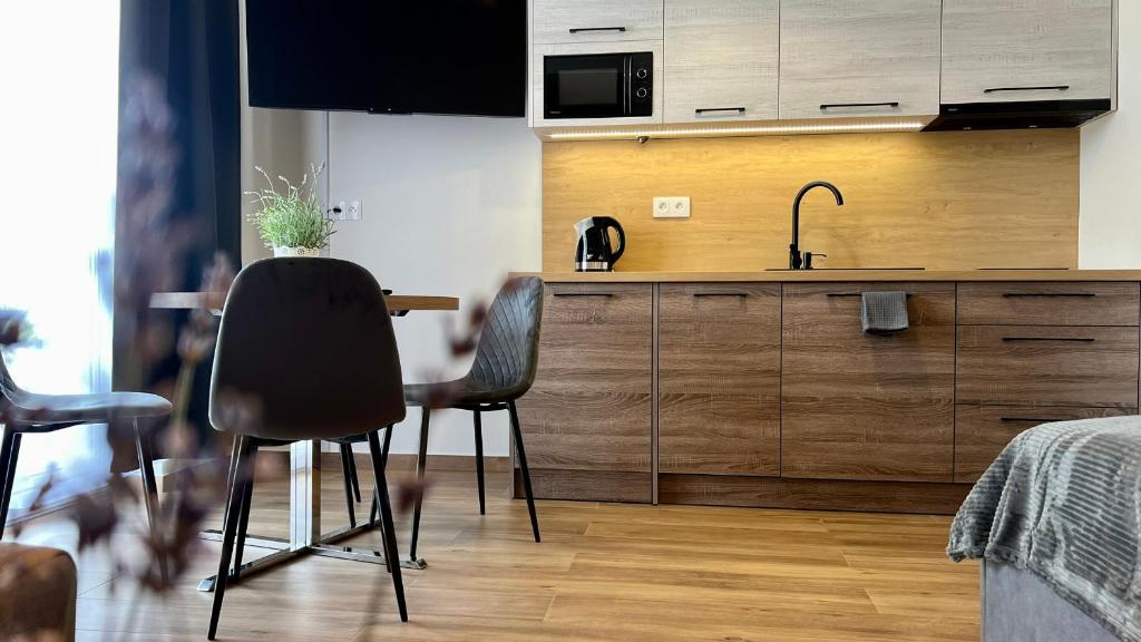 une cuisine avec une table, des chaises et un évier dans l'établissement Rising Sun 3 by Housine,pl, à Zator