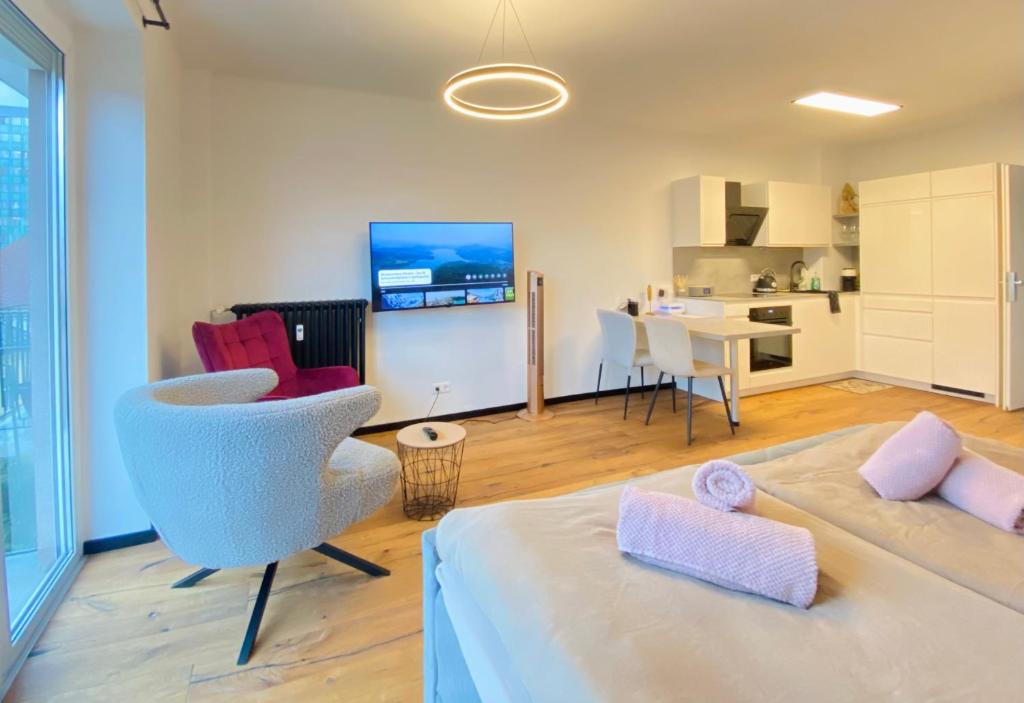 Zimmer mit einem Bett und einem Stuhl sowie einer Küche in der Unterkunft BaMo Studio - city living downtown in Klagenfurt am Wörthersee