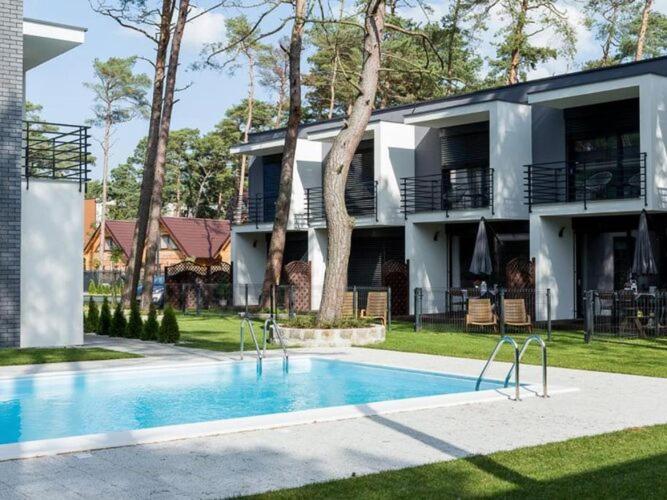 uma casa com piscina em frente a uma casa em Terraced houses, outdoor pool, Pobierowo em Pobierowo