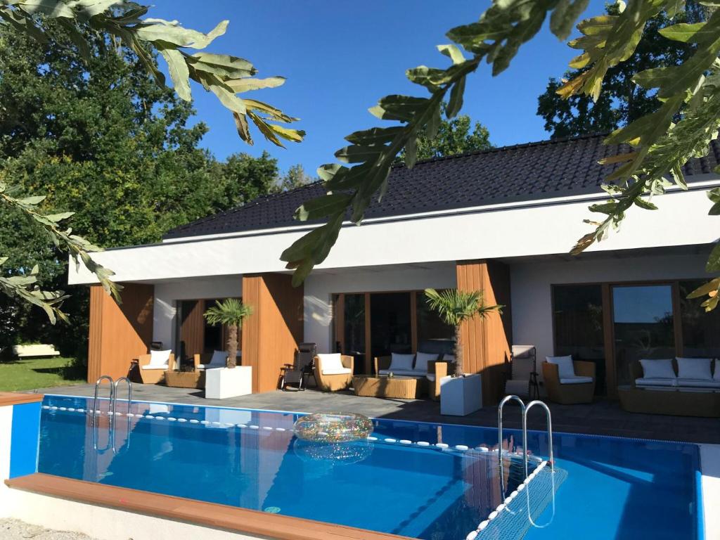 a villa with a swimming pool in front of a house at House with swimming pool in Swinoujscie for 16 people in Świnoujście