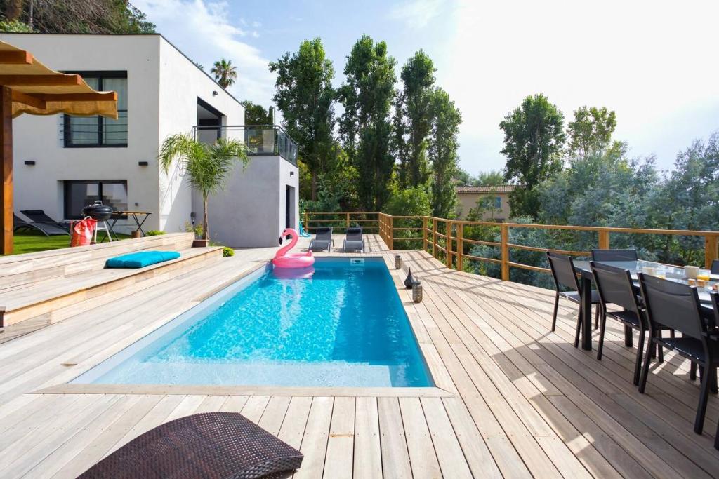 a swimming pool on a deck with a table and chairs at Villa modern Super-Cannes heated Pool, Parking, CLIM, 7 min to Cannes Beach in Vallauris