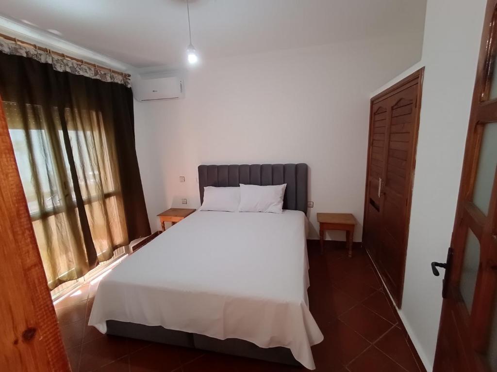 a bedroom with a white bed and a window at Residence Family OULANTI in Martil