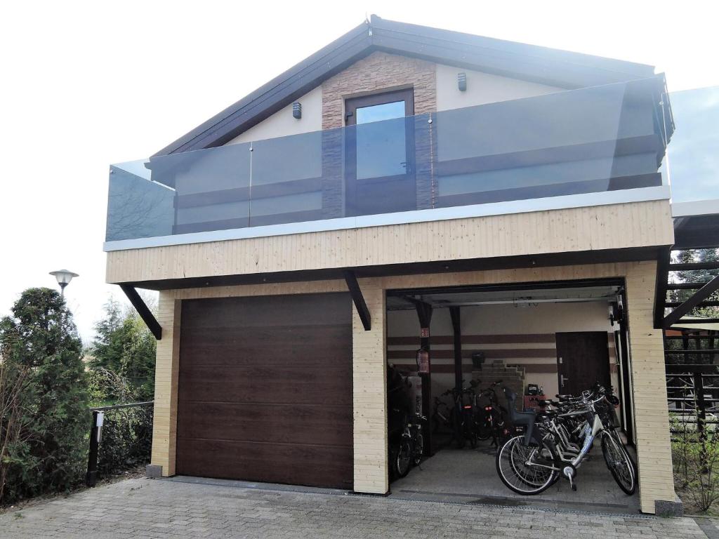 a house with two bikes parked in the garage at Nice holiday home in Miedzywodzie with parking in Międzywodzie