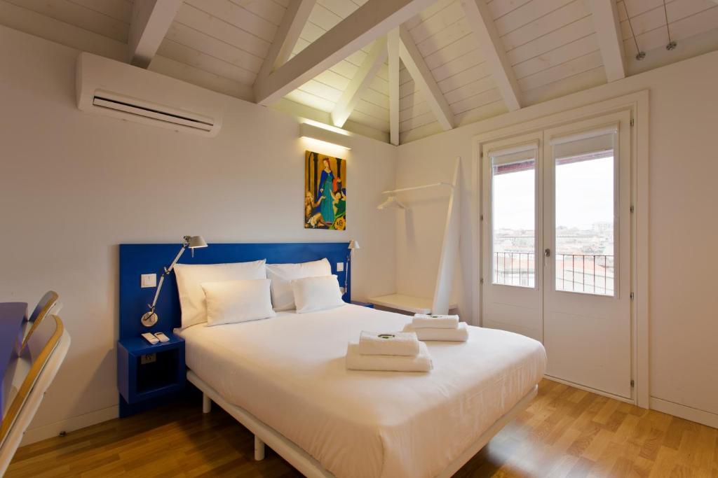 a bedroom with a blue and white bed and a window at Downtown Cosy Suite VI in Porto