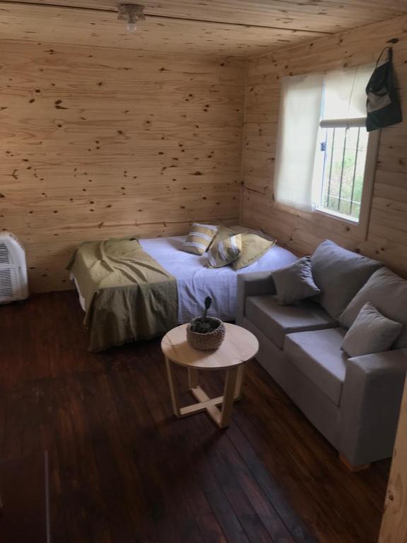 um quarto com um sofá, uma cama e uma mesa em Campo verde II em Concordia