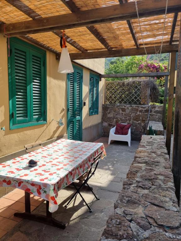 a patio with a table under a wooden pergola at Mia House in Porto Vecchio