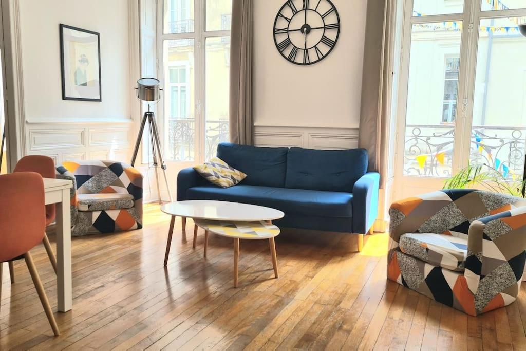 Una sala de estar con un sofá azul y una mesa. en L'Haussmannien - Hyper centre - Bords de l'Erdre, en Nantes