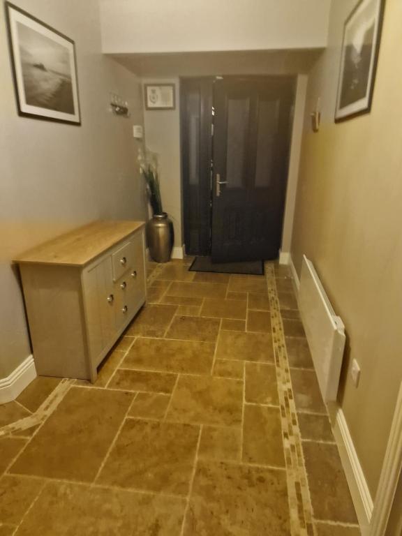 a hallway with a tiled floor with a cabinet at Shanadune in Tralee