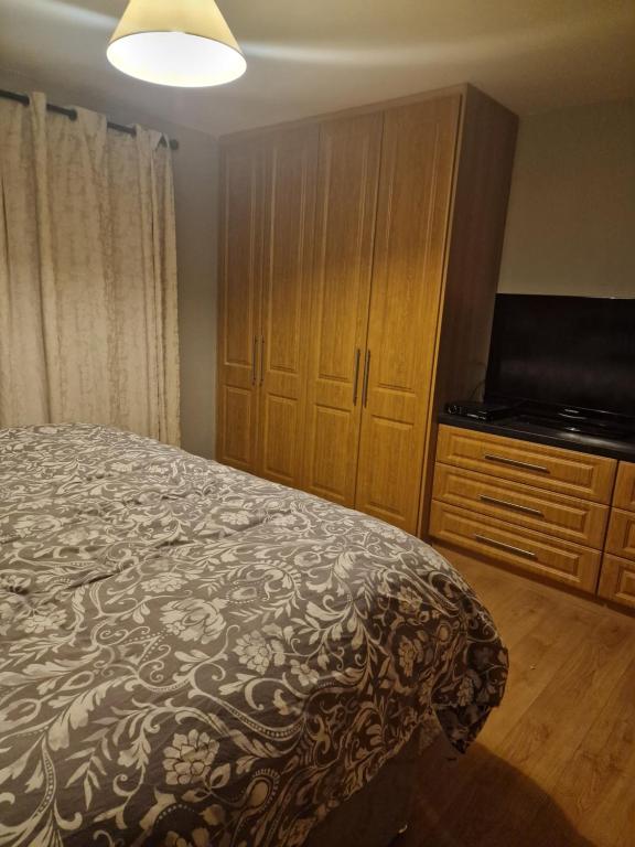 a bedroom with a bed and a flat screen tv at Shanadune in Tralee