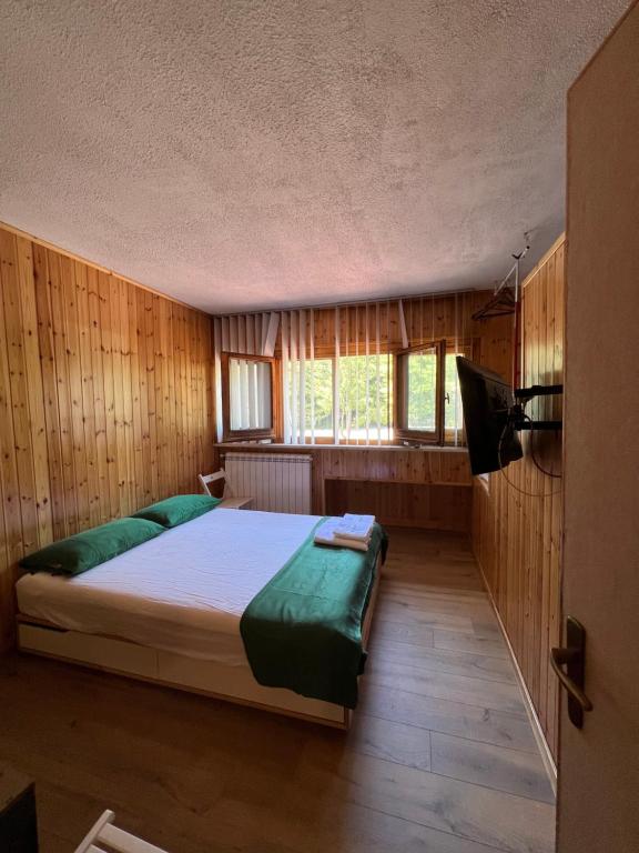 1 dormitorio con 1 cama en una habitación con paredes de madera en Cataleya Laceno, en Laceno