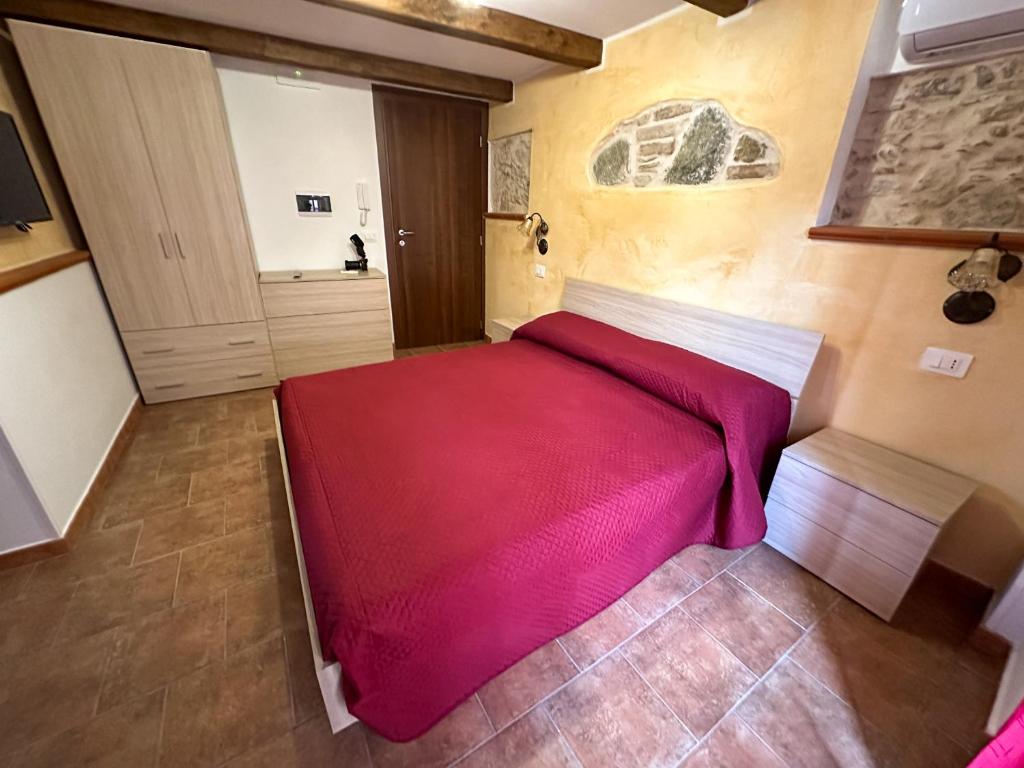 a bedroom with a bed with a red blanket at ARA Home in Marcellinara