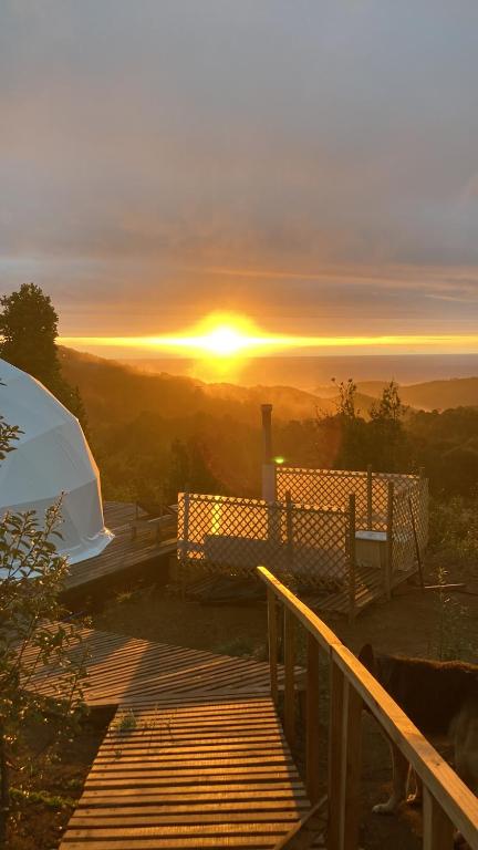 uitzicht op een zonsondergang vanaf een terras met een tent bij Domo con tinaja, Estaquilla in Los Muermos