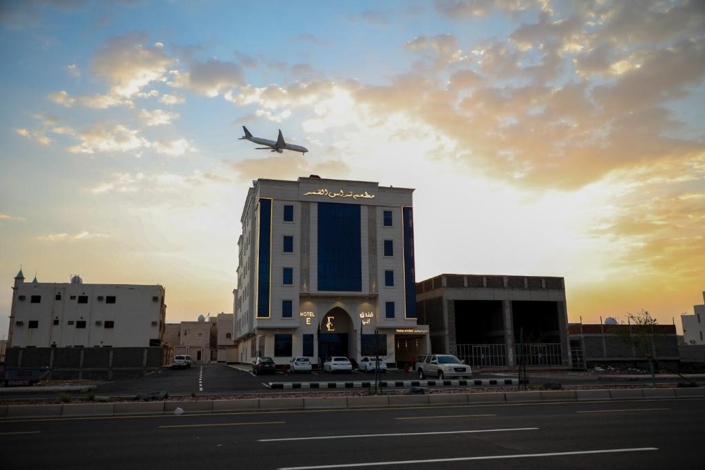 an airplane is flying over a building with a building at فندق ايي E Hotel in Al Madinah