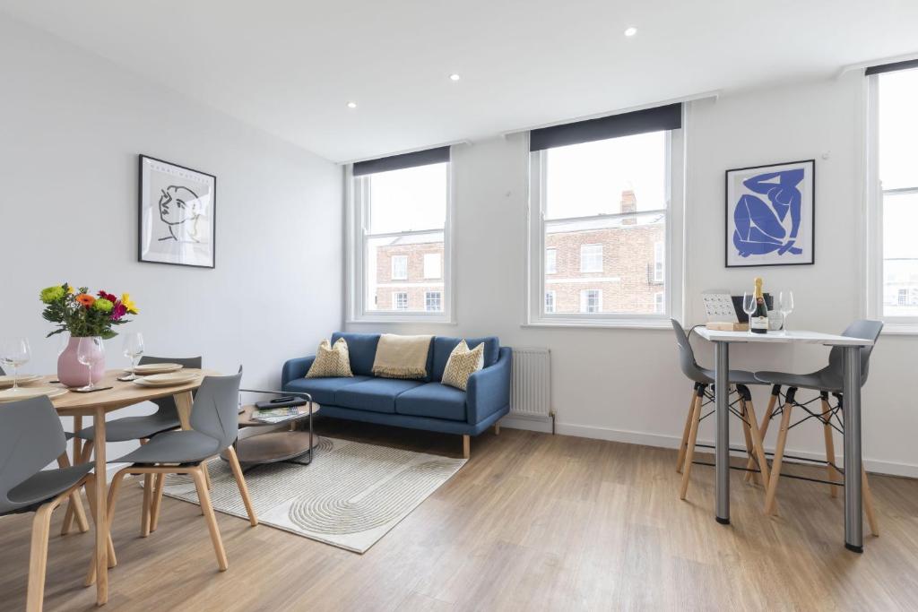 a living room with a blue couch and a table at Beautifully presented newly renovated city-centre apartment in Cheltenham in Cheltenham