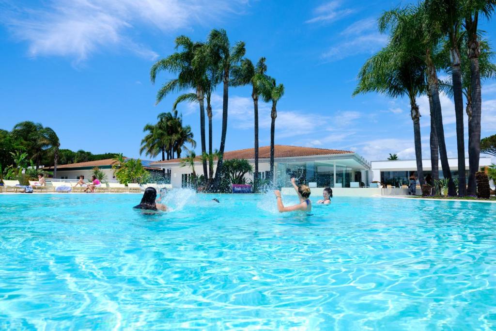 a group of people in a swimming pool with palm trees at Mia Resort Paestum in Paestum