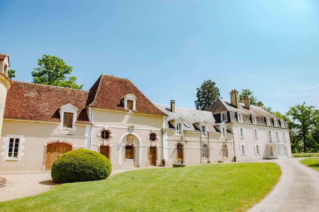 una vista exterior de una gran casa con entrada en Château de Villefargeau en Villefargeau