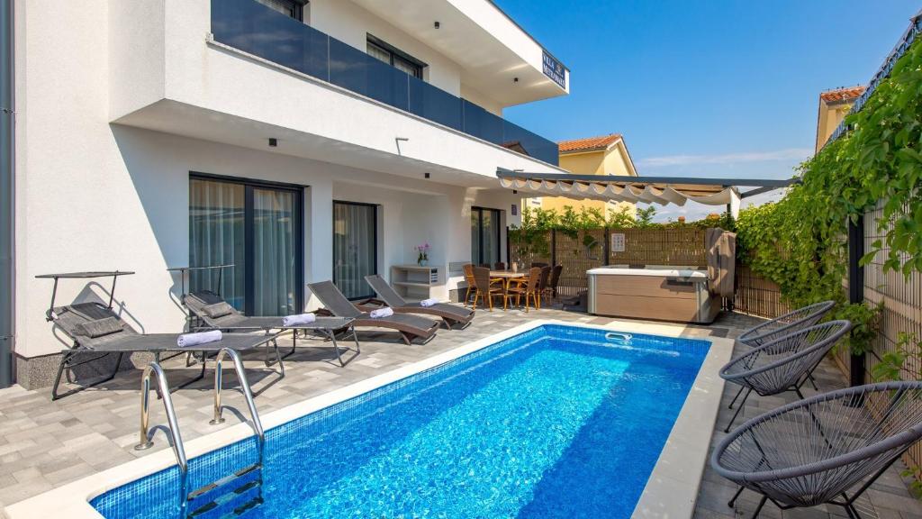een villa met een zwembad en een huis bij Luxury Villa MetraMaris1 in Malinska