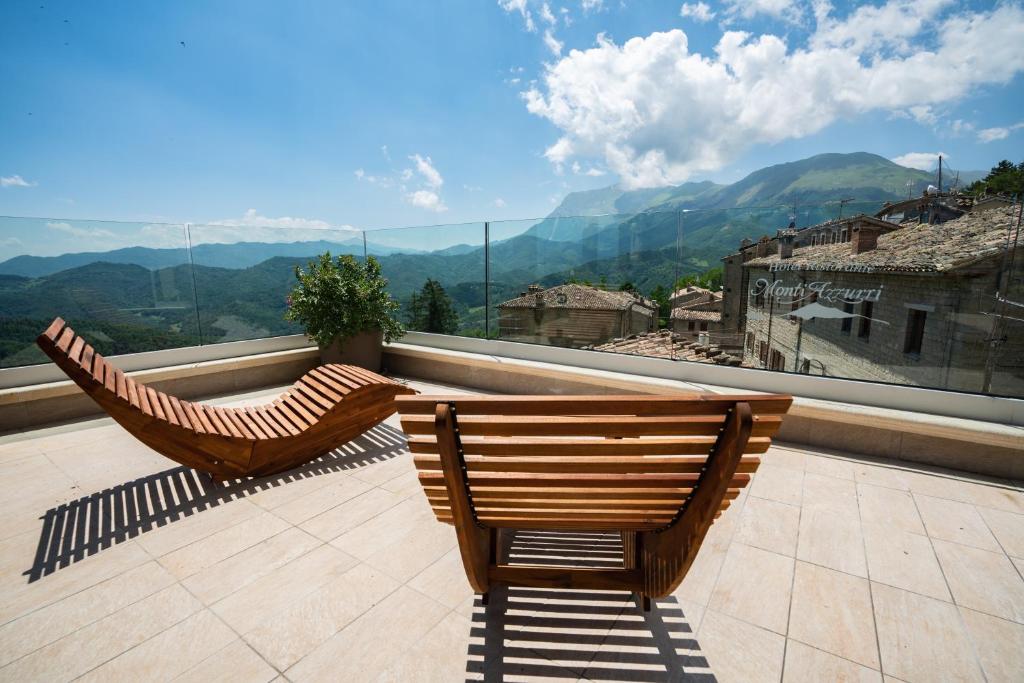 two chairs on a balcony with a view of mountains at Monti Azzurri in Montemonaco