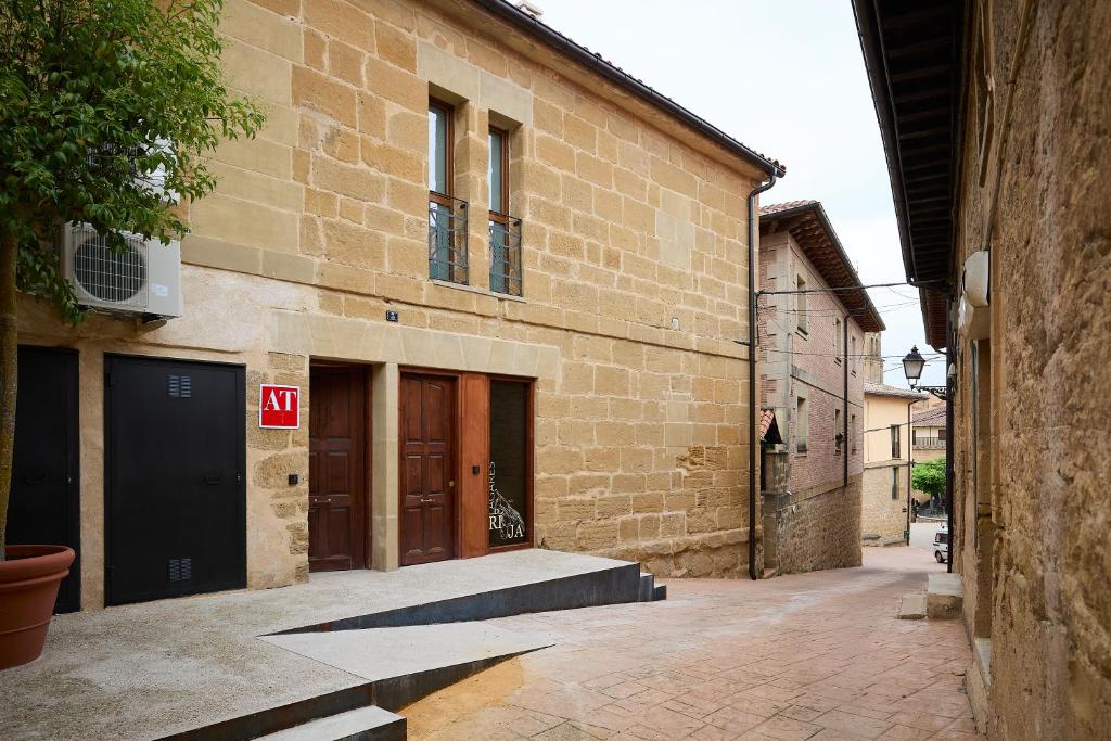 an alley with a building with two doors and a stairway at Lagares de Riooja-Briñas in Briñas