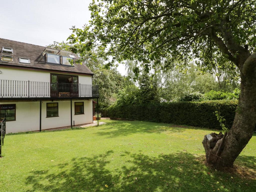 a house with a tree in the yard at Hillcroft in Kenilworth