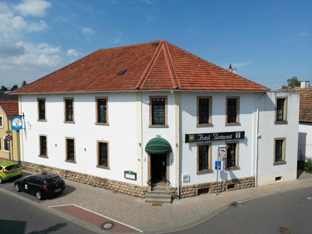um grande edifício branco com um telhado vermelho em Family & Friends em Haßloch