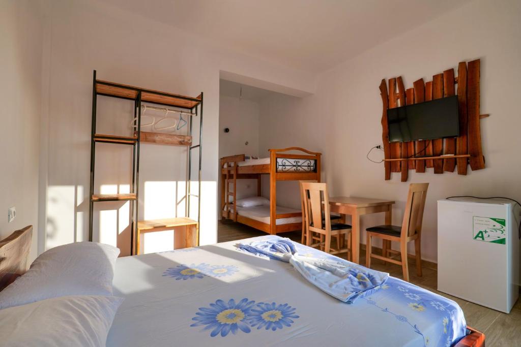una camera con letto e una sala da pranzo con tavolo di Tropikal Freskia Bunec a Sarandë