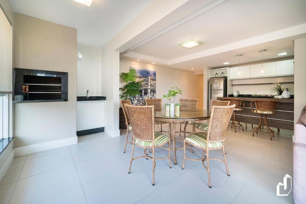 cocina y comedor con mesa y sillas en Kremer Residence - Apartamento 302: Com todos os ambientes climatizados, en Bombinhas