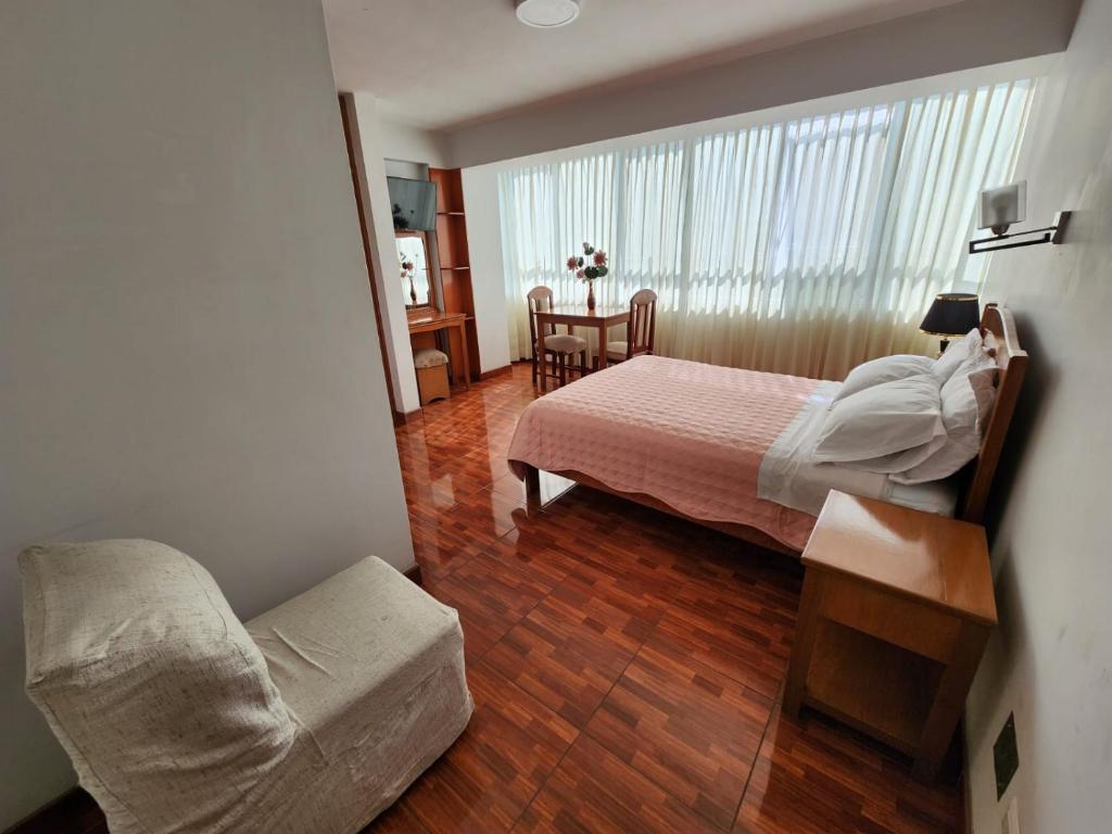 1 dormitorio con 1 cama y 1 silla en una habitación en Hotel Oceano Mit en Tacna