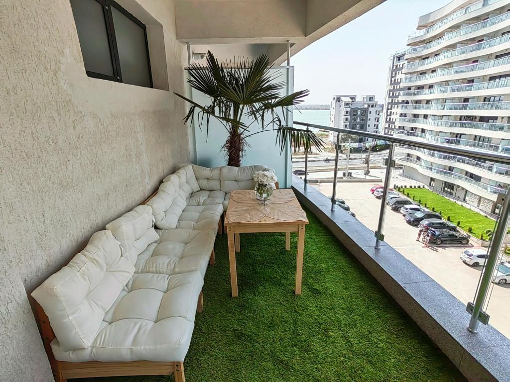 uma sala de estar com um sofá e uma mesa na varanda em The Palm Studio em Mamaia