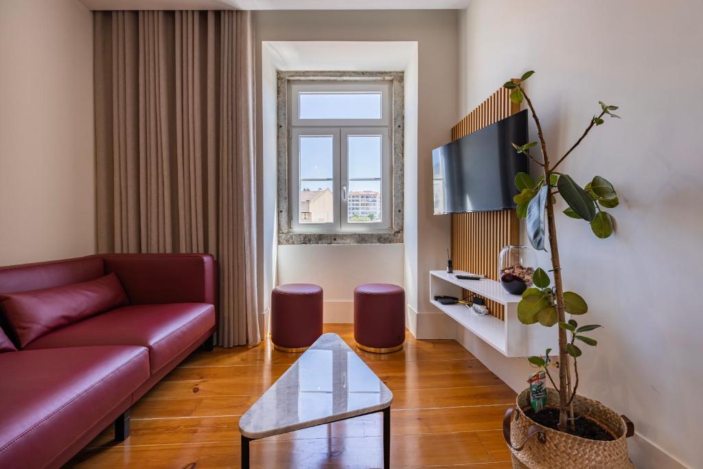 a living room with a red couch and a tv at Liberdade Concept 2BDR Apartment by LovelyStay in Lisbon