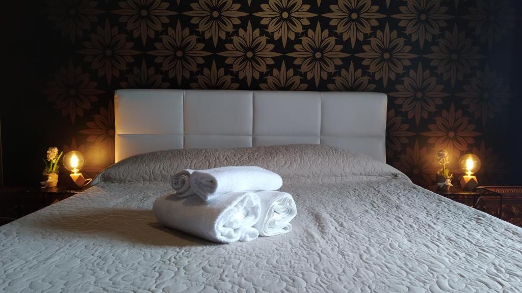 CconfortHotels R&B Dolci Emozioni - SELF CHECK IN في باري: غرفة نوم عليها سرير وفوط