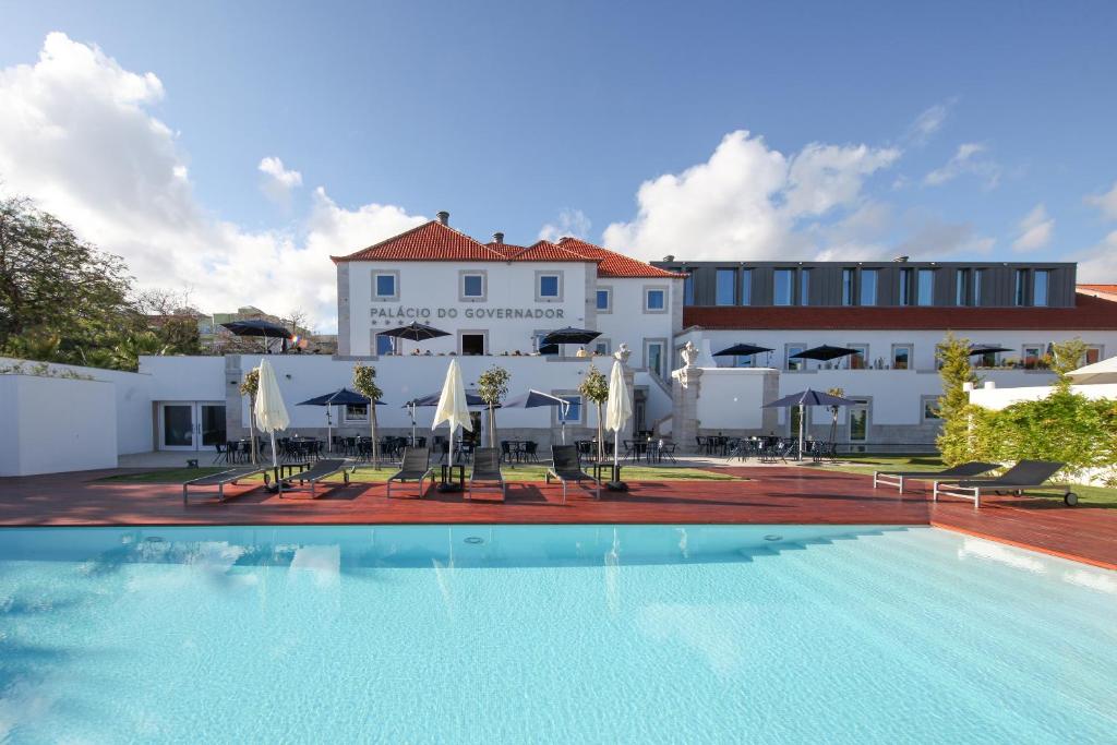 um hotel com piscina em frente a um edifício em NAU Palacio do Governador em Lisboa