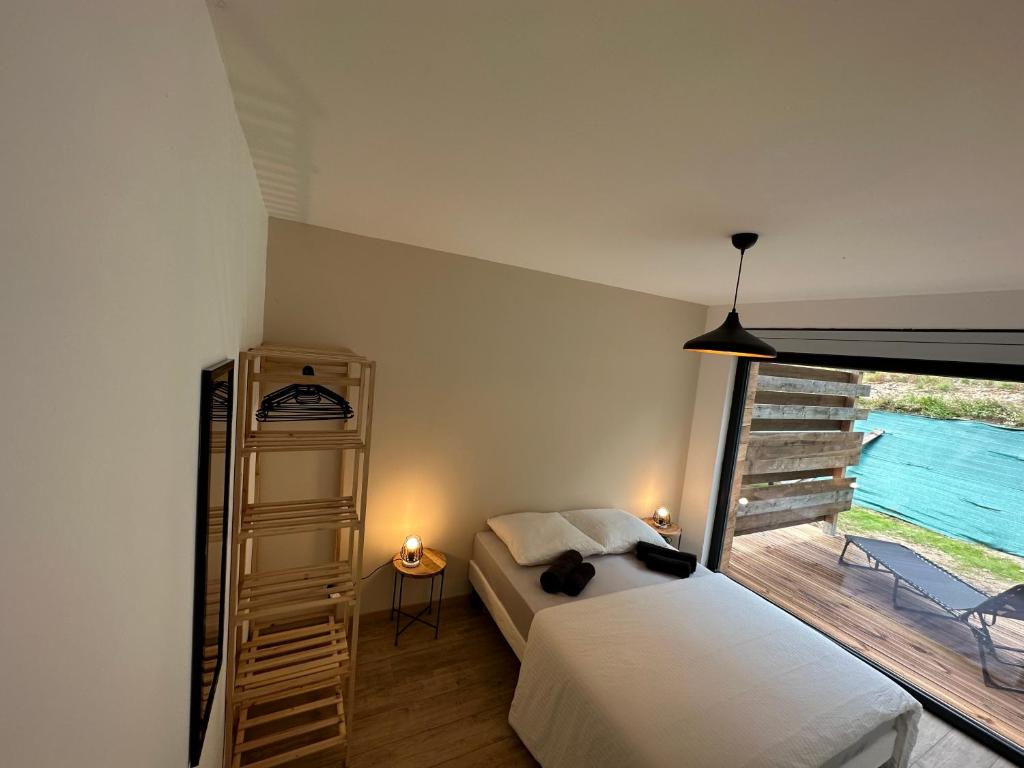 ein Schlafzimmer mit einem Bett und einem Balkon in der Unterkunft Chalet de l'ancienne école, Jacuzzi privé in Gérardmer