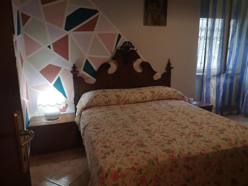 a bedroom with a bed and a geometric wall at APE REGINA Rignano extension in Rignano Flaminio