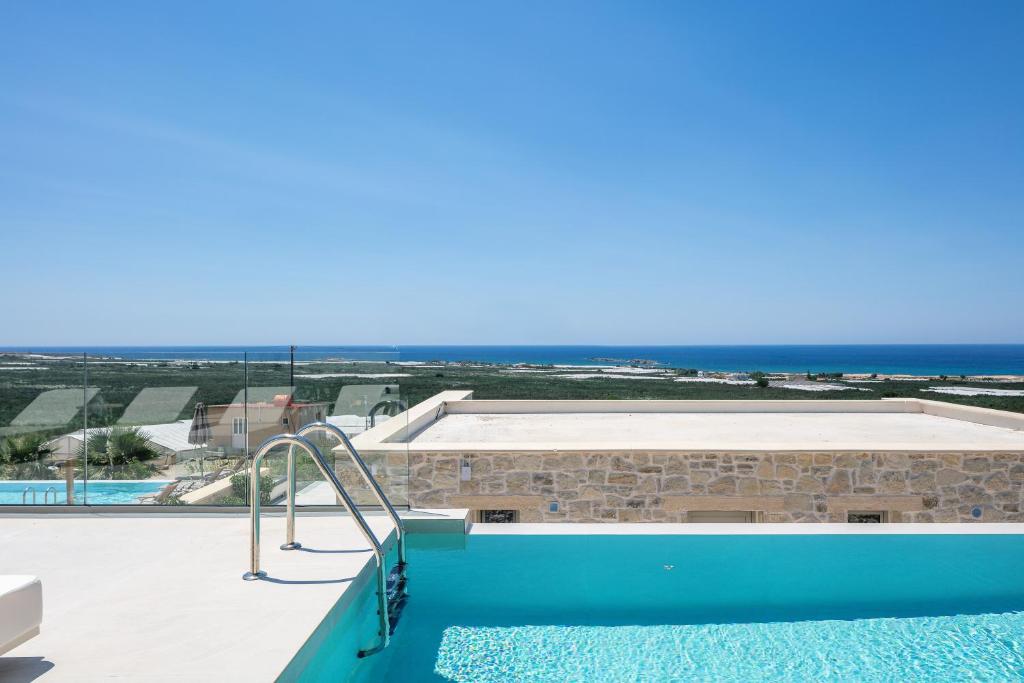 a view of a swimming pool and the ocean at Petras Resort in Falasarna