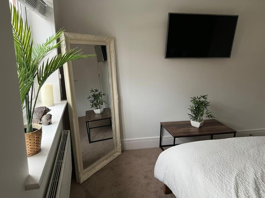 a bedroom with a bed and a mirror and a tv at Stunning Home in Astley in Tyldesley