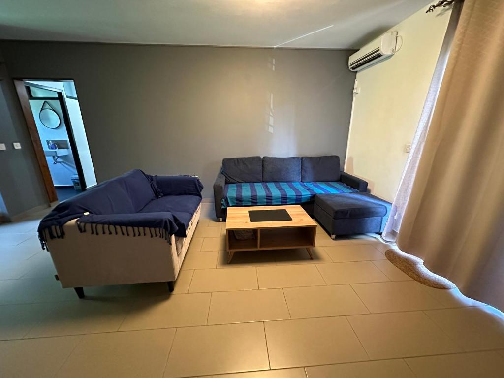 ein Wohnzimmer mit einem Sofa und einem Couchtisch in der Unterkunft Trou aux Biches Apartment in Trou aux Biches