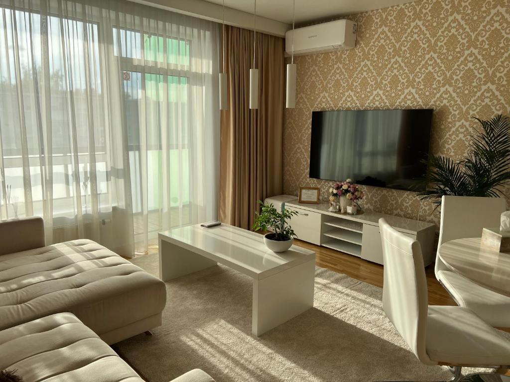 a living room with a couch and a tv at Antakalnis 5 stars apartment in Vilnius