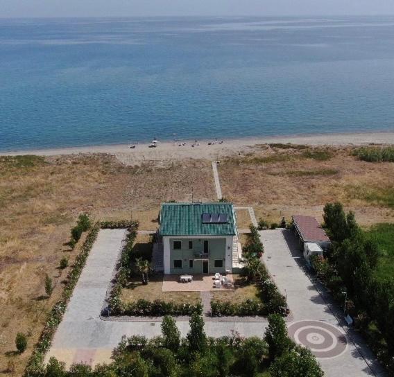 a house with a green roof on a beach at Green House Beach in Mandatoriccio Marina