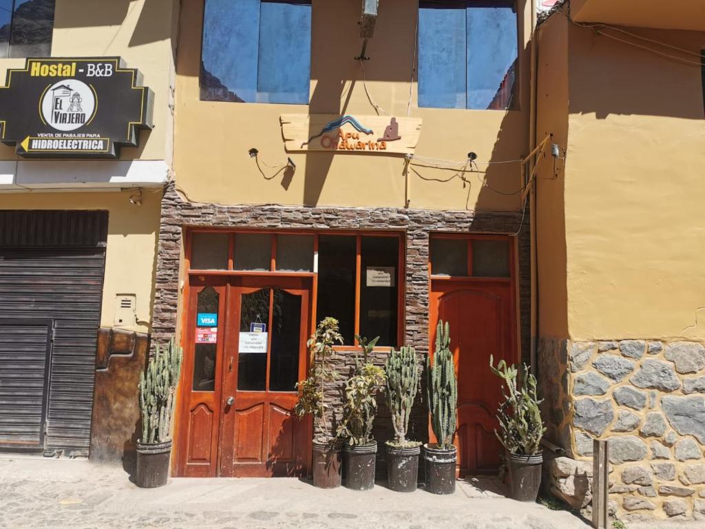 Un bâtiment avec deux portes et un cacti devant lui dans l'établissement Hostal Apu Qhawarina, à Ollantaytambo