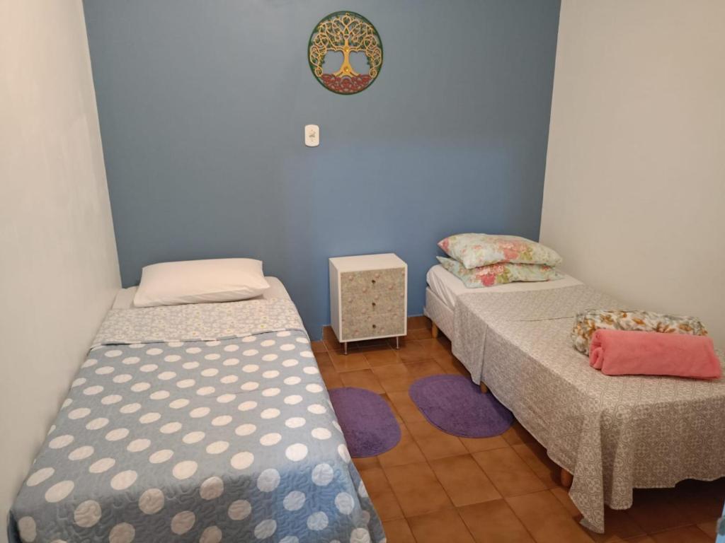 2 łóżka pojedyncze w pokoju z niebieskimi ścianami w obiekcie Varanda Hospedaria - SP Expo Hospedagem w São Paulo