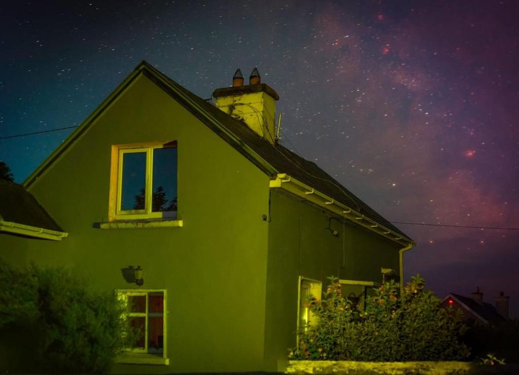 a green house with a lighthouse on top of it at night at Peaceful Cottage in Cork