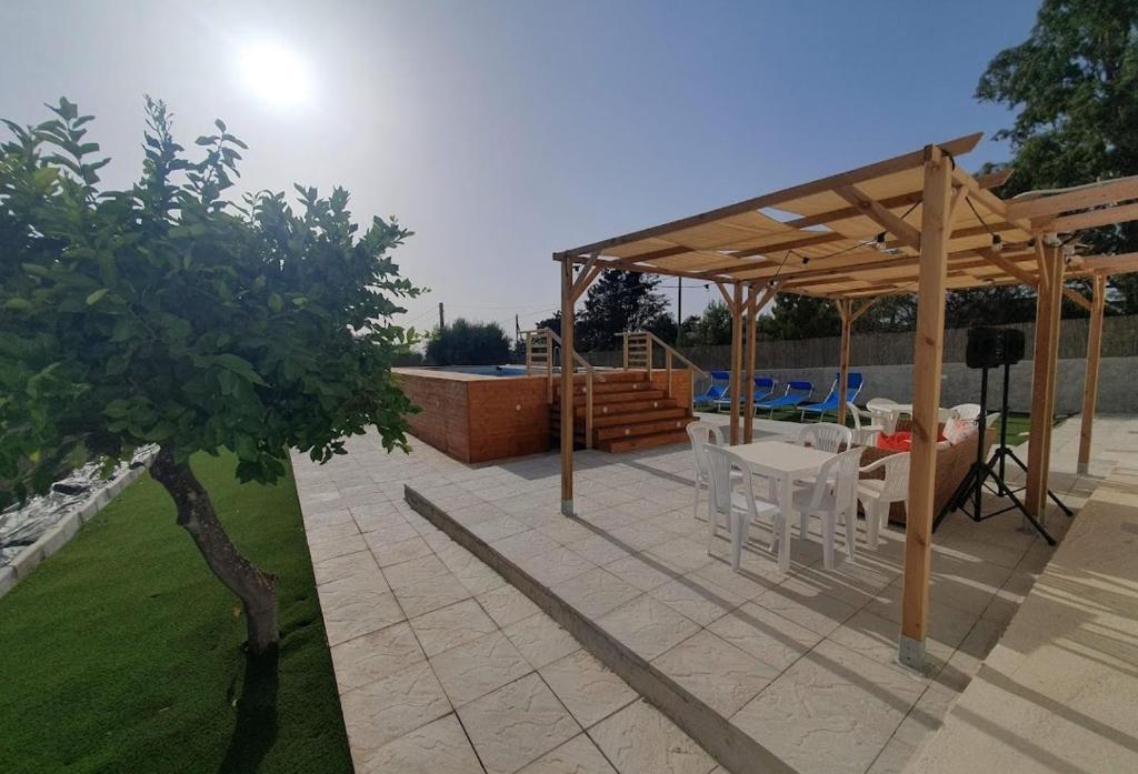 un patio avec une table et des chaises sous un pavillon dans l'établissement IL GUFO DELLA MARZA, à Ispica