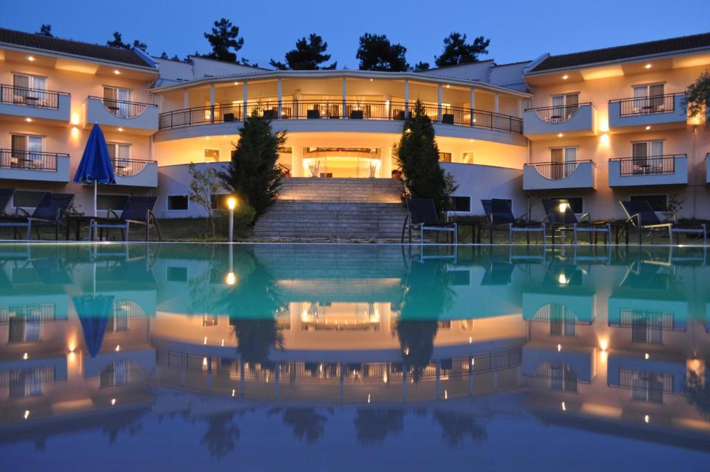 a hotel with a swimming pool at night at Kohylia by La Scala Beach in Limenas