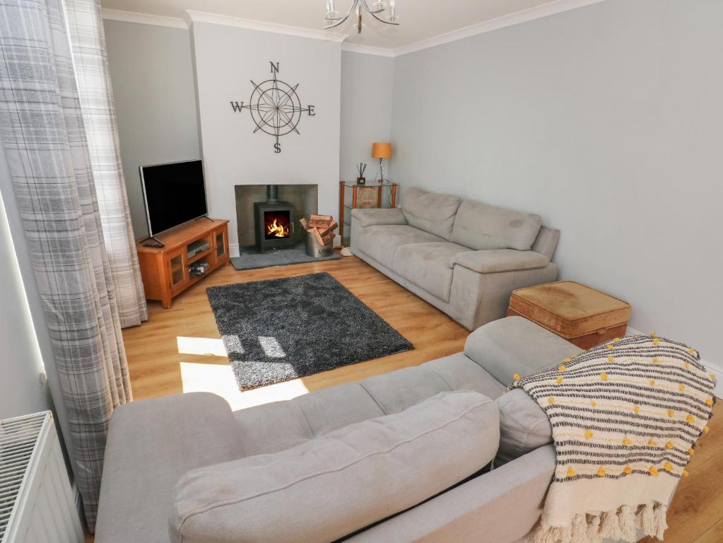 a living room with a couch and a fireplace at Afan House in Port Talbot