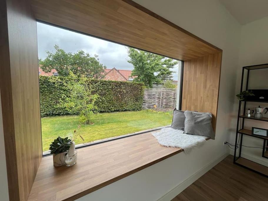 a window seat in a room with a view of a yard at Boldermountain Guesthouse in Heusden - Zolder